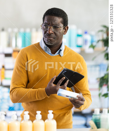 Adult man scanning qr code of ointment Adult man scanning qr code of ointment 125531328