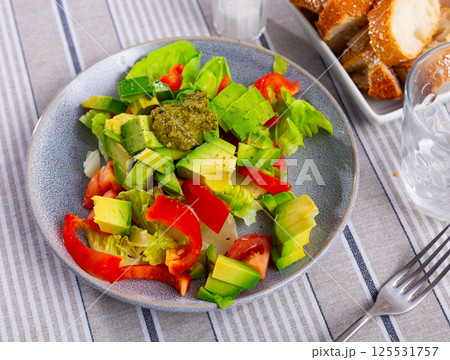 Plate contains portion of salad from fresh vegetables and pesto sauce. Plate contains portion of salad from fresh vegetables and pesto sauce. 125531757