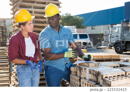 Man and woman in outdoor construction material storage Man and woman in outdoor construction material storage 125532425