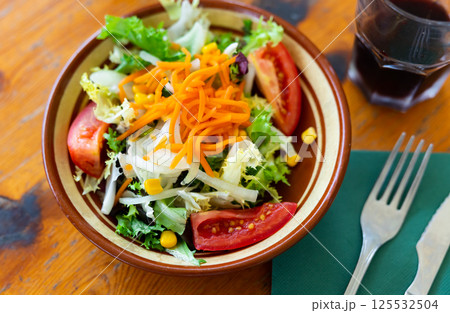 Plate contains portion of salad from fresh China cabbage, carrot, corn 125532504