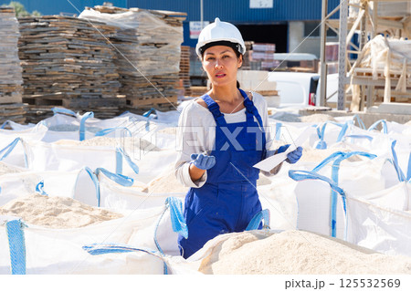 Manager leads the accounting sandbags at the construction site an open-air site Manager leads the accounting sandbags at the construction site an open-air site 125532569