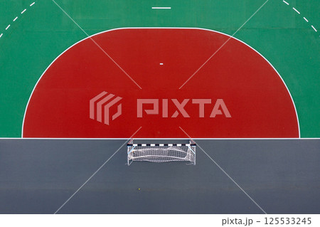 Aerial view of a sports court with basketball and goal areas on a sunny day 125533245