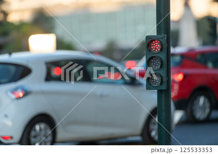 Traffic signal with red light near busy intersection during early evening rush hour Traffic signal with red light near busy intersection during early evening rush hour 125533353