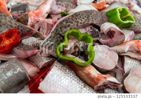 Fresh fish and vegetables prepared for cooking at a bustling market in the city 125533537