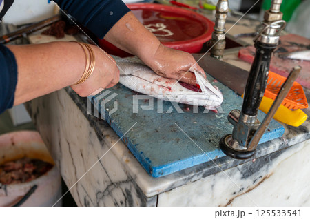 Preparing fresh fish at a market stall in the early morning Preparing fresh fish at a market stall in the early morning 125533541