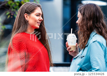 two emotional teenage girlfriends laughing and talking on the street, friendship concept two emotional teenage girlfriends laughing and talking on the street, friendship concept 125534426