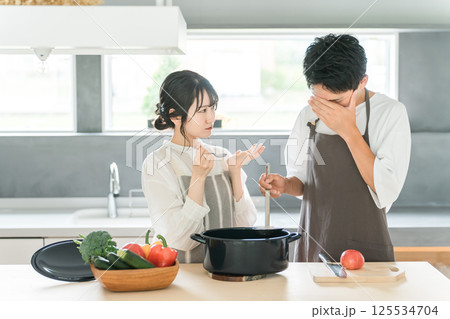 料理を作って味見をする夫婦・カップル・男女(キッチン) 料理を作って味見をする夫婦・カップル・男女(キッチン) 125534704
