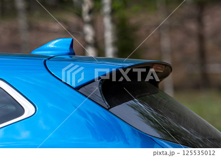 Detail of a blue sports car in the forest. Selective focus Detail of a blue sports car in the forest. Selective focus 125535012
