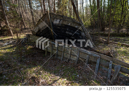 Old abandoned wooden fishing boat in the forest. Boats cemetery. Old abandoned wooden fishing boat in the forest. Boats cemetery. 125535075