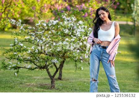 Woman posing in spring garden. Blurred background with copy space. Woman posing in spring garden. Blurred background with copy space. 125536132