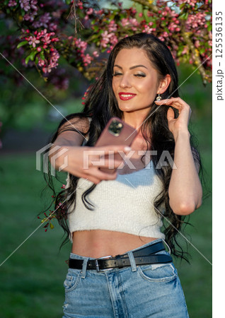 Woman taking selfie in springtime park. Shallow depth of feld 125536135