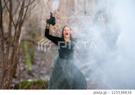 Woman in forest surrounded by smoke. Shallow depth of feld Woman in forest surrounded by smoke. Shallow depth of feld 125536616