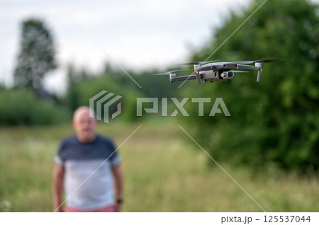 drone copter flying in the air with blurred man on background 125537044