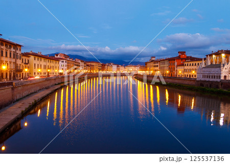 Panoramic view of the old town of Pisa and the Arno river at twilight, Italy. Night cityscape 125537136