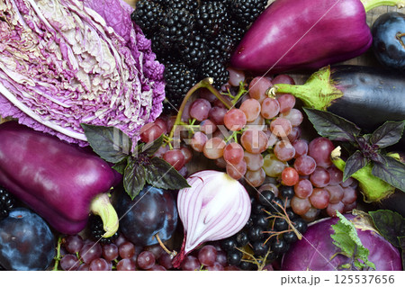 Assortment of vibrant purple vegetables and fruits including cabbage grapes eggplants and garlic on a rustic wooden surface perfect for healthy food concepts organic markets and vegetarian themes Assortment of vibrant purple vegetables and fruits including cabbage grapes eggplants and garlic on a rustic wooden surface perfect for healthy food concepts organic markets and vegetarian themes 125537656
