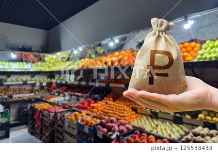 Russian rubles money bag on the background of a grocery store counter with fresh organic vegetables and fruits. Concept of cost of goods and food products. Grocery set. Import and export 125538438