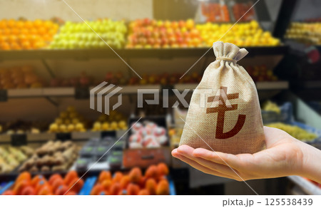 Turkish lira money bag on the background of a grocery store counter with fresh organic vegetables and fruits. Concept of cost of goods and food products. Grocery set. Import and export 125538439