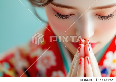 赤い着物を着て合掌する女性 125538462