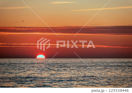 Peaceful Sunset Over the Sea.A breathtaking sunset paints the sky with vibrant orange, pink and purple hues, casting a golden glow over the calm sea waters. Peaceful Sunset Over the Sea.A breathtaking sunset paints the sky with vibrant orange, pink and purple hues, casting a golden glow over the calm sea waters. 125539446