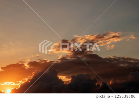 Glorious Sunrise Over Serene Ocean.A breathtaking sunrise illuminates the sky with vibrant hues of orange, pink, and gold, reflecting over the calm ocean waters.  125539500