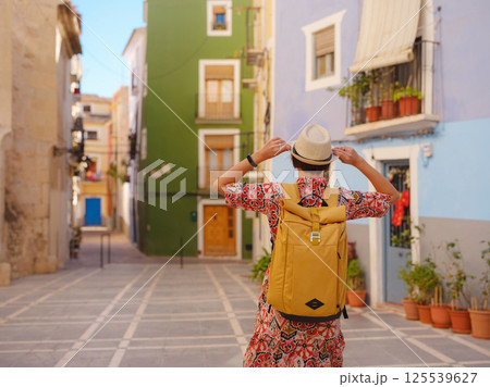 Woman strolls through colorful streets of Spanish coastal town Woman strolls through colorful streets of Spanish coastal town 125539627