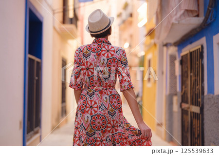 Woman strolls through colorful streets of Spanish coastal town Woman strolls through colorful streets of Spanish coastal town 125539633