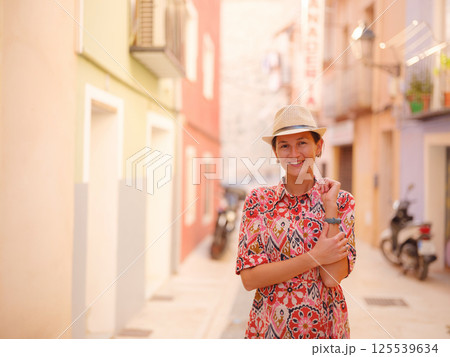 Woman strolls through colorful streets of Spanish coastal town Woman strolls through colorful streets of Spanish coastal town 125539634