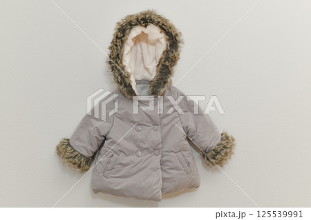 Grey-lilac colored winter jacket hanging on hanger on white background 125539991