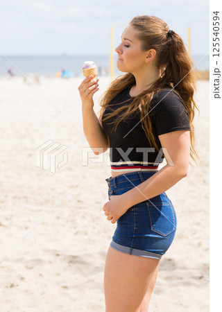 Young woman eating ice cream Young woman eating ice cream 125540594