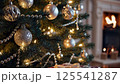 Decorated christmas tree silver gold ornaments glowing lights warm fireplace background cozy home interior festive holiday season family atmosphere peace 125541287