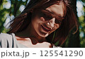 Woman face eyes closed serene smile enjoys sun warm light outdoors nature background happiness peace tranquility mindfulness wellbeing relaxation bliss 125541290