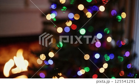 Vibrant christmas lights bokeh soft focus glowing multicolor circles blurred fireplace background festive party atmosphere abstract holiday pattern shimmer 125541291