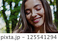 Woman nature wellness beauty outdoor forest setting gentle smile mindful moment peaceful lifestyle spiritual practice meditation healing journey sunlight positive energy harmony 125541294