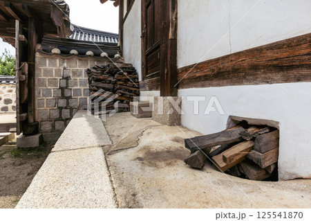 Stacked firewood and traditional wood feeding hole for ondol floor heating system at a historic Korean hanok house Stacked firewood and traditional wood feeding hole for ondol floor heating system at a historic Korean hanok house 125541870