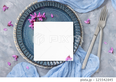 Wedding table place with a card near fabric and wild purple flowers top view on gray, spring mockup Wedding table place with a card near fabric and wild purple flowers top view on gray, spring mockup 125542845