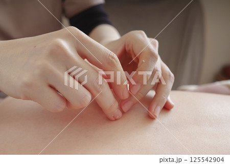 鍼灸院で背中に鍼治療をする女性 125542904