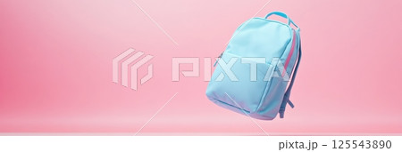 Minimalist still life showcasing a light blue backpack floating on a vibrant pink backdrop, creating a striking visual contrast and a sense of weightlessness 125543890