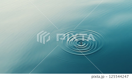 Concentric ripples expanding outwards from the point of impact of a single water droplet, creating a mesmerizing pattern on a calm, blue water surface, evoking tranquility and mindfulness Concentric ripples expanding outwards from the point of impact of a single water droplet, creating a mesmerizing pattern on a calm, blue water surface, evoking tranquility and mindfulness 125544247