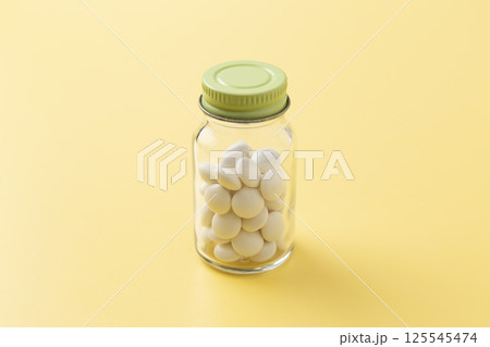 黄色背景に錠剤 黄色背景に錠剤 125545474