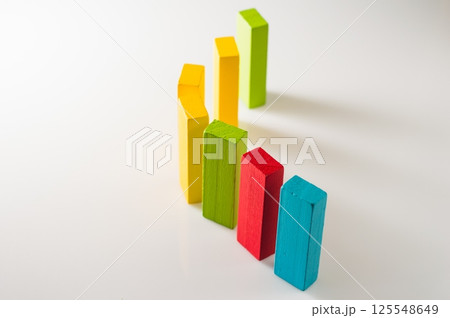 Developmental wooden blocks rest on a light background. The colorful pieces look bright and harmonious. 125548649