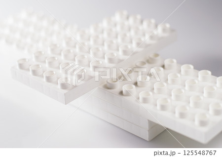The plastic construction set for children consists of numerous colorful modules. The elements are connected without any specific order. The plastic construction set for children consists of numerous colorful modules. The elements are connected without any specific order. 125548767