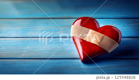 Close-up of a Wooden Red Heart with Adhesive Bandage on Blue Wooden Table - Generative Ai 125548826