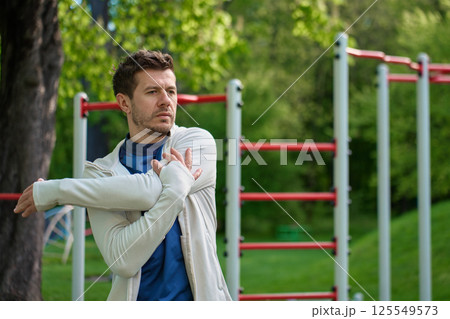 Man stretching before outdoor workout in park. Athlete prepares for training 125549573