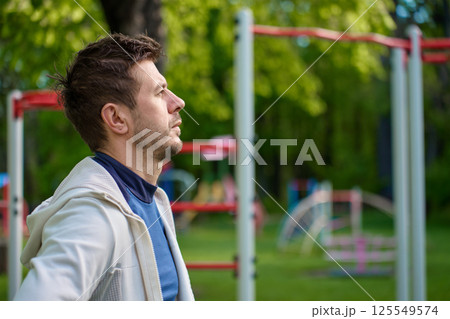 Man in sportswear preparing for workout at outdoor fitness park 125549574