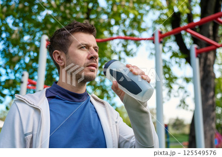 Man drinking water during outdoor workout Man drinking water during outdoor workout 125549576