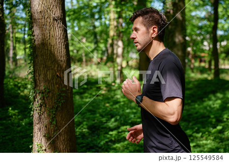 Man running on forest trail in summer morning. Healthy lifestyle jogging 125549584