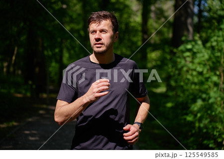 Man running on forest trail in summer morning. Healthy lifestyle jogging 125549585