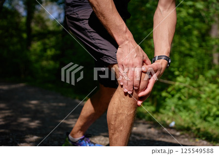 Man suffering from knee pain during running in park Man suffering from knee pain during running in park 125549588