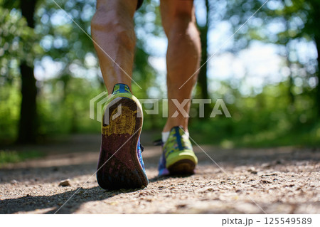 Runner shoes close-up on forest trail during outdoor workout Runner shoes close-up on forest trail during outdoor workout 125549589