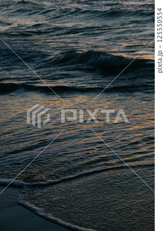 Ocean with waves, sunset sky is orange. water is choppy and waves are crashing on shore. Ocean with waves, sunset sky is orange. water is choppy and waves are crashing on shore. 125550554